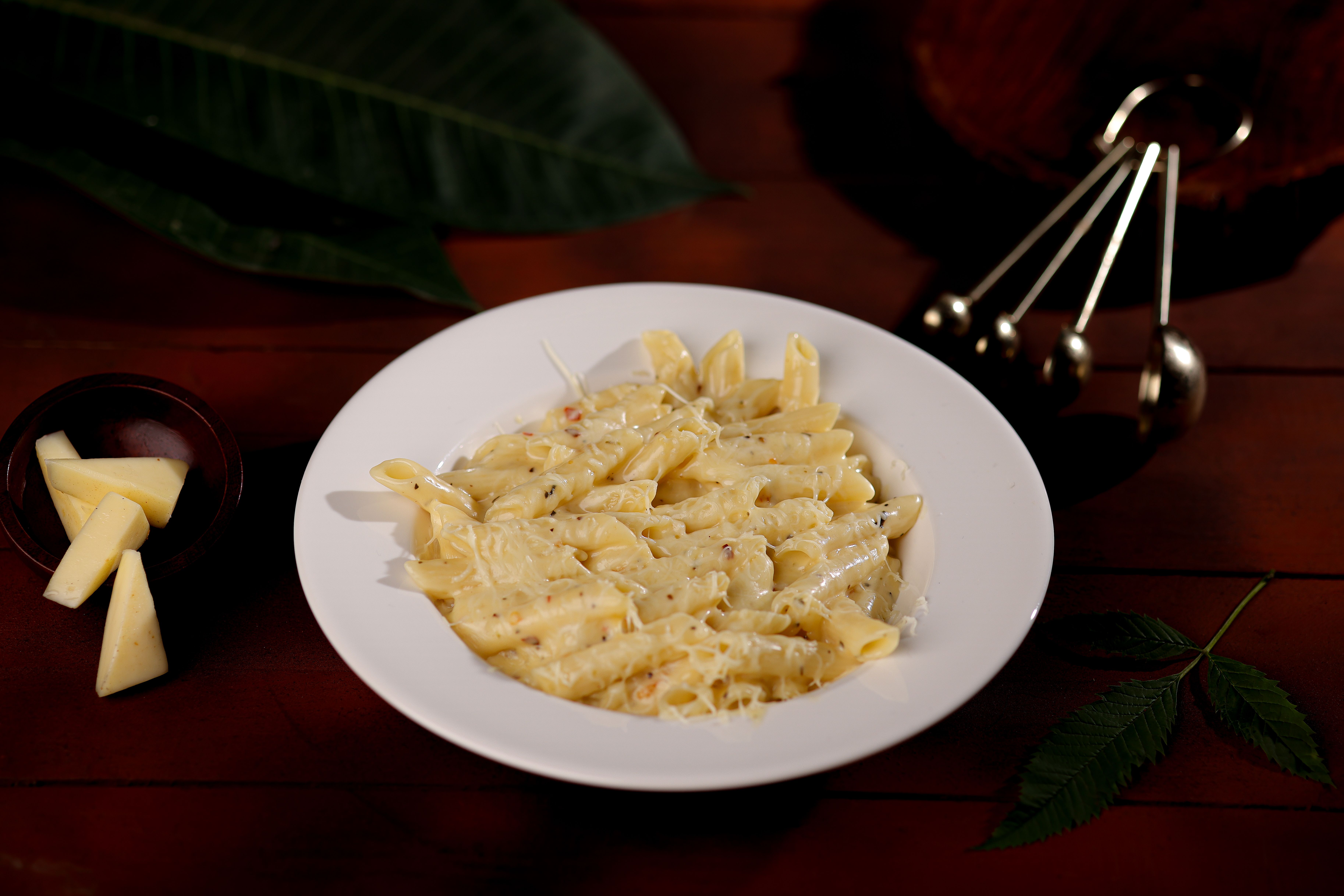 Delicious creamy penne pasta served with melted cheese, ready to enjoy.