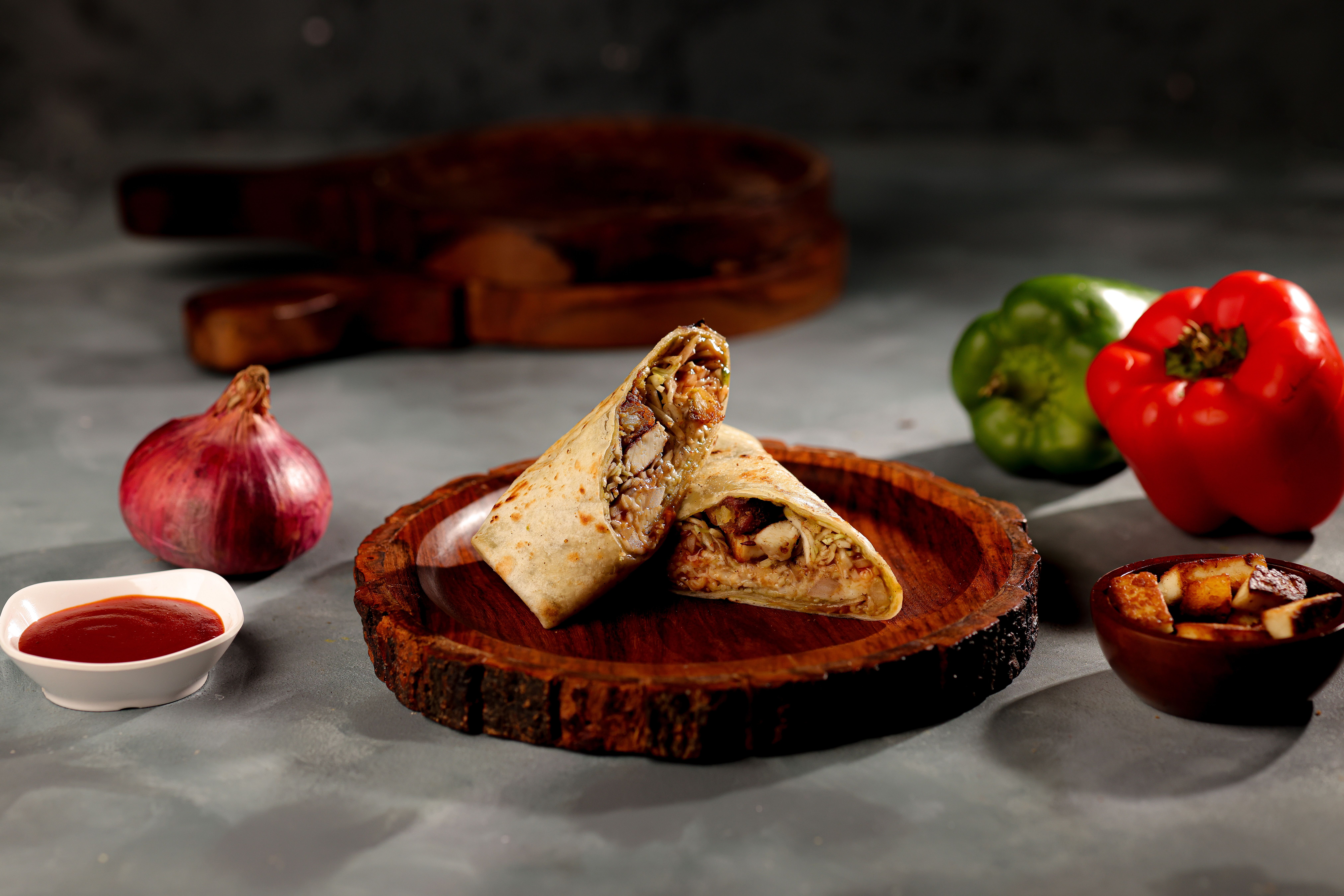 Un délicieux wrap au poulet servi sur un plateau en bois avec des légumes frais et de la sauce.