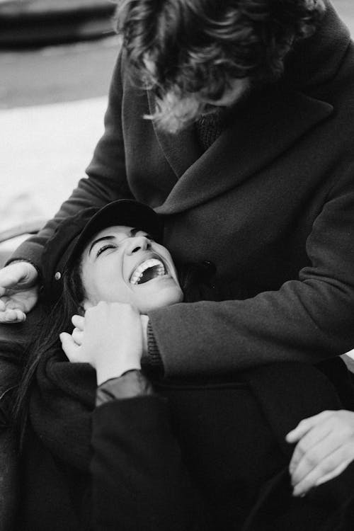 웃는 동안 남자의 무릎에 누워 여자의 흑백 사진