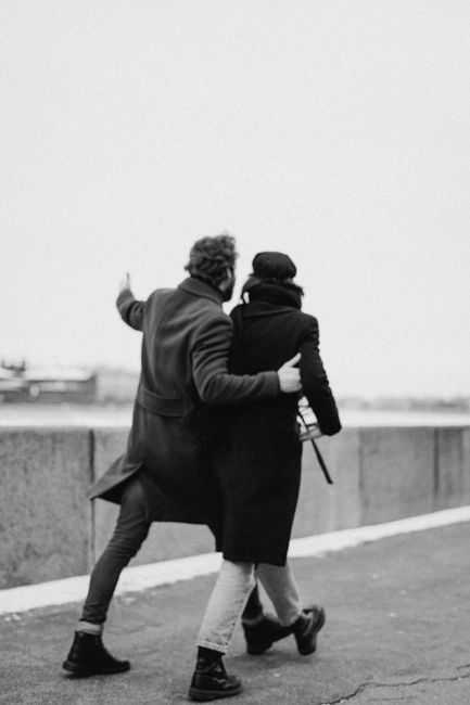 A couple walking arm in arm outdoors on a cold day, showcasing romance and togetherness.