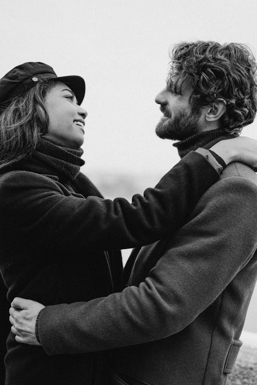Monochrome Photo of Man and Woman Hugging While Looking to Each Other