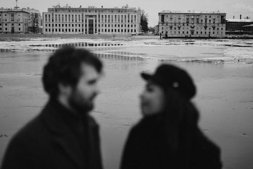Free Blurred Photography on Man and Woman Behind Buildings Stock Photo