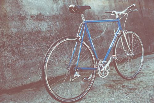 Free Classic blue bicycle parked outdoors with vintage aesthetic and urban style. Stock Photo