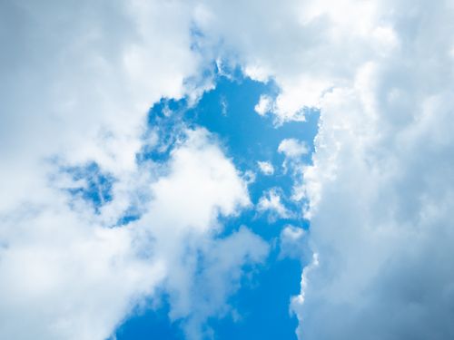 Free Bright blue sky with fluffy white clouds creating a serene and peaceful atmosphere. Stock Photo