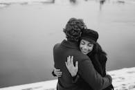 一对夫妇在白雪皑皑的湖边相拥，温暖地分享着爱与幸福