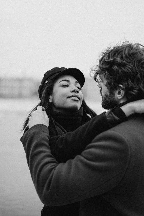 Free A black and white photo of a couple embracing outdoors, showcasing love and romance. Stock Photo