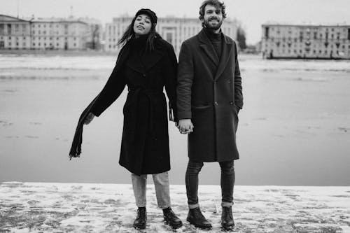 Man and Woman Holding Hands on Black and White Photography