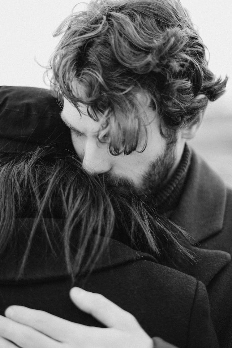 Grayscale Photo Of Man Hugging Person