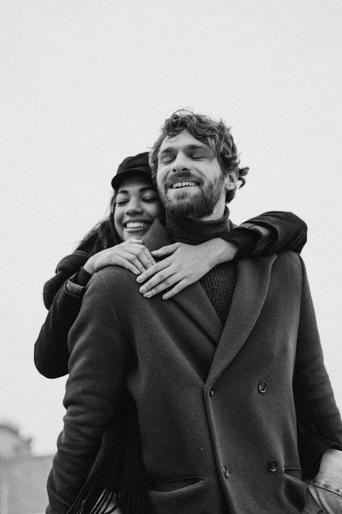 Woman Hugging Man Wearing Black Coat