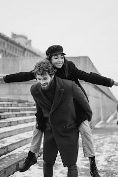 一对快乐的夫妇在冬天以灰度拍摄的方式享受户外背负式骑行