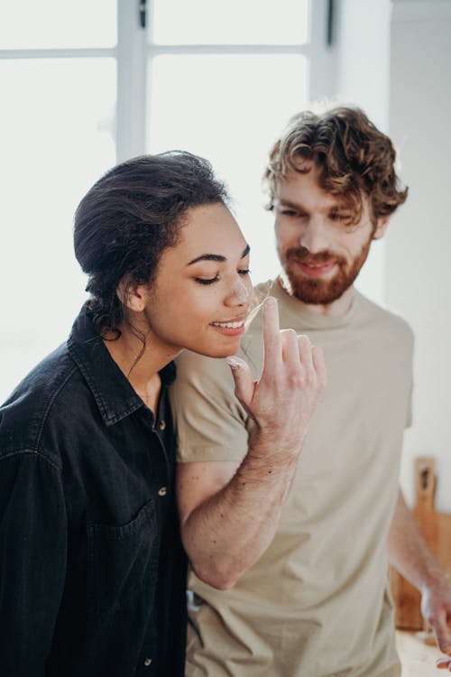 Wanita Dengan Jaket Denim Hitam Di Samping Pria Dengan Kemeja Beige Crew Neck