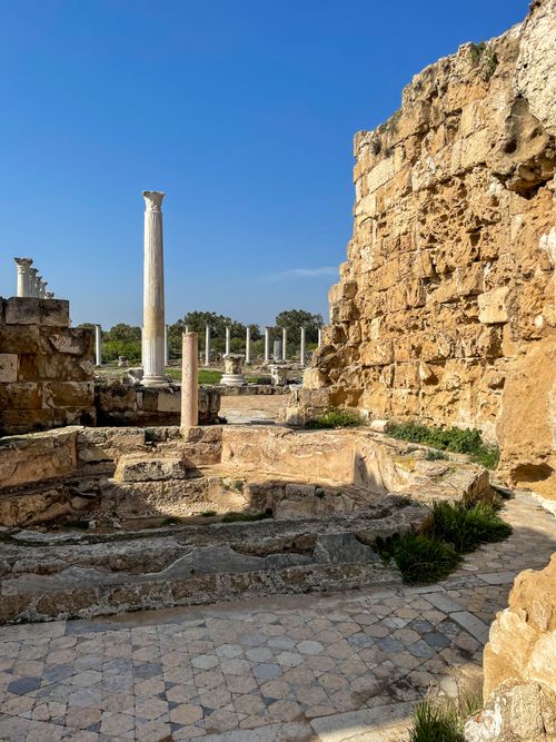Free Majestic view of ancient Roman ruins with standing columns and old stone walls under a clear blue sky. Stock Photo