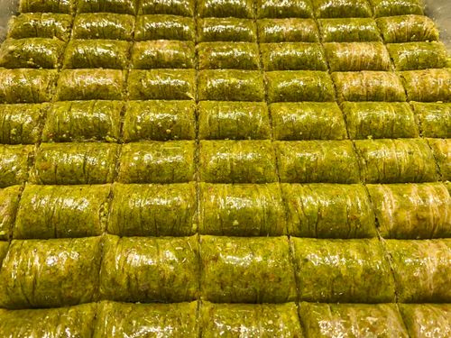 Free Rows of delicious Turkish Fistikli Sarma, rich with pistachio and honey, showcasing a traditional treat. Stock Photo