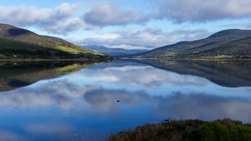 Free Beautiful reflection of mountains and clouds in a lake, offering a serene landscape vision. Stock Photo