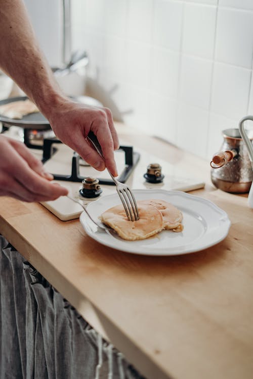 Free Person Holding Fork and Knife on White Ceramic Plate Stock Photo