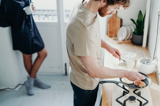 A man preparing pancakes in a cozy home kitchen, adding a warm start to the day.