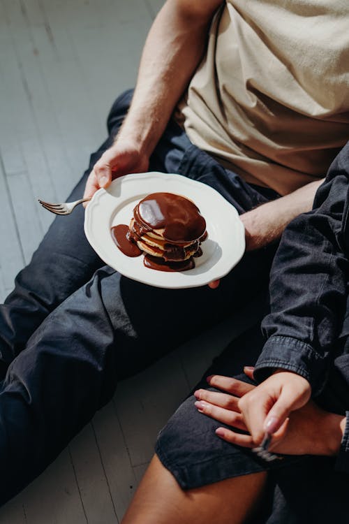 チョコレートパンケーキとプレートを保持している人