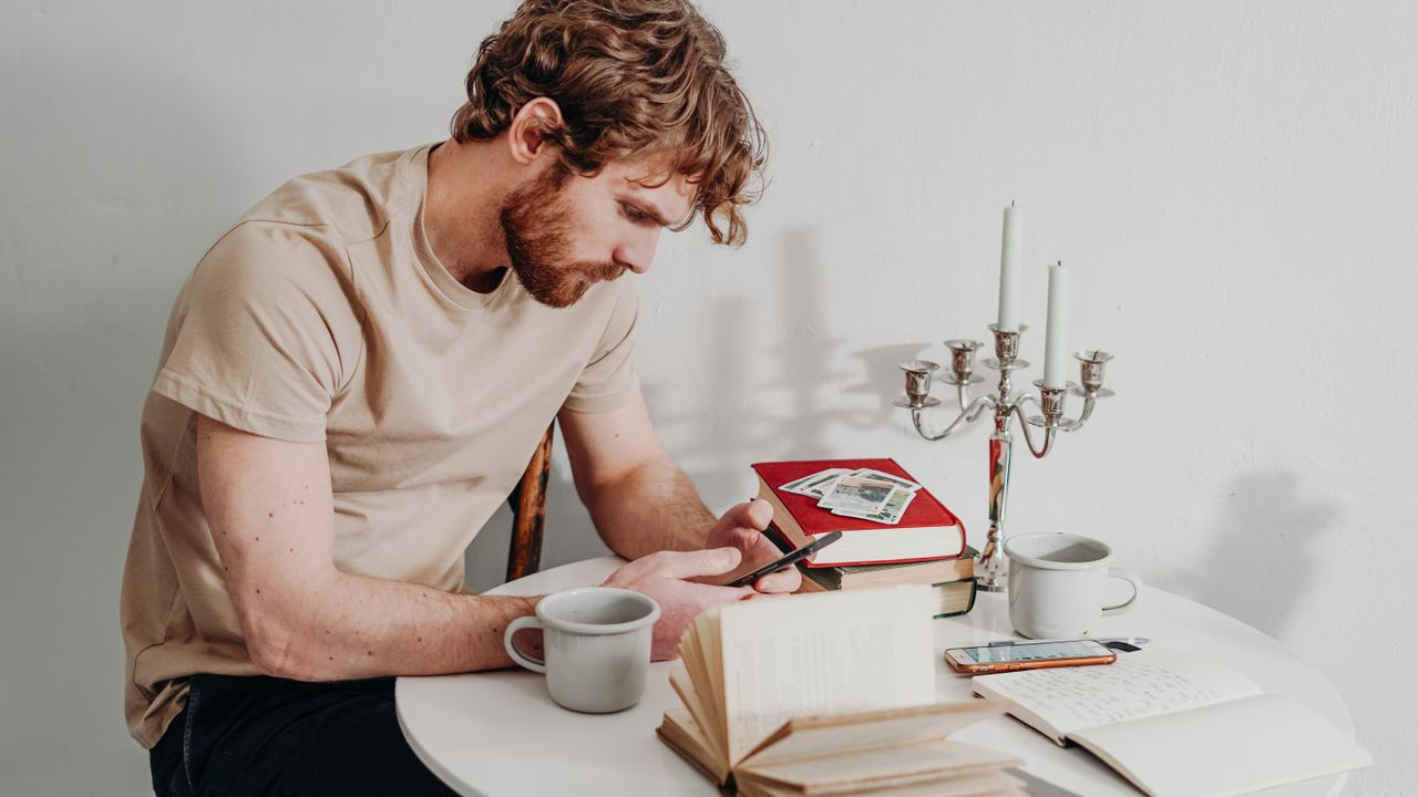 Intentional smartphone use and reading Person using a smartphone beside books while practicing more intentional digital habits