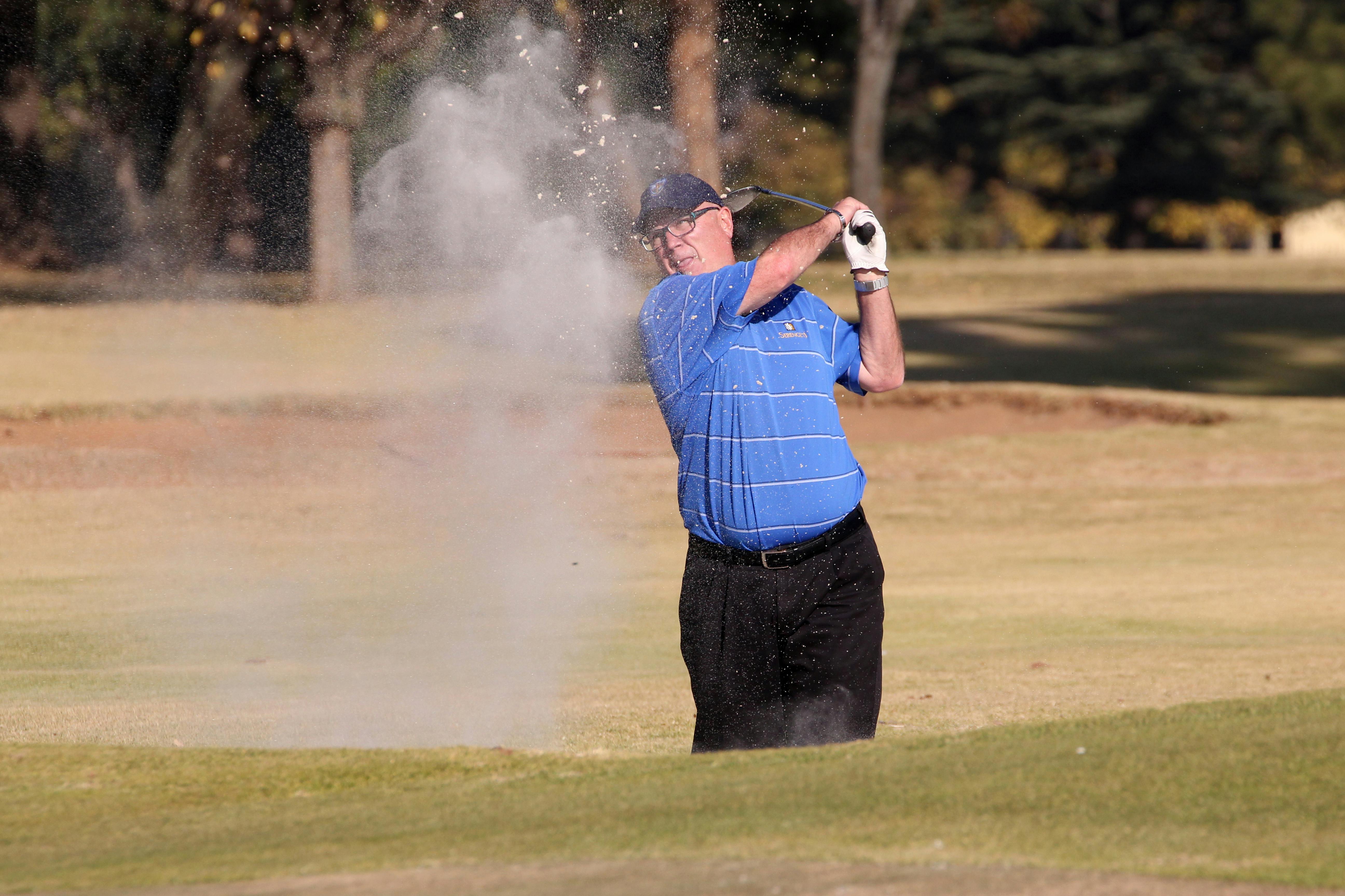 man hitting a golf ball