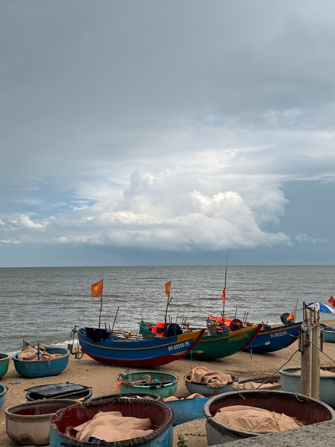 Vietnamese Fishing Boats on Beach Under Cloudy Sky · Free Stock Photo