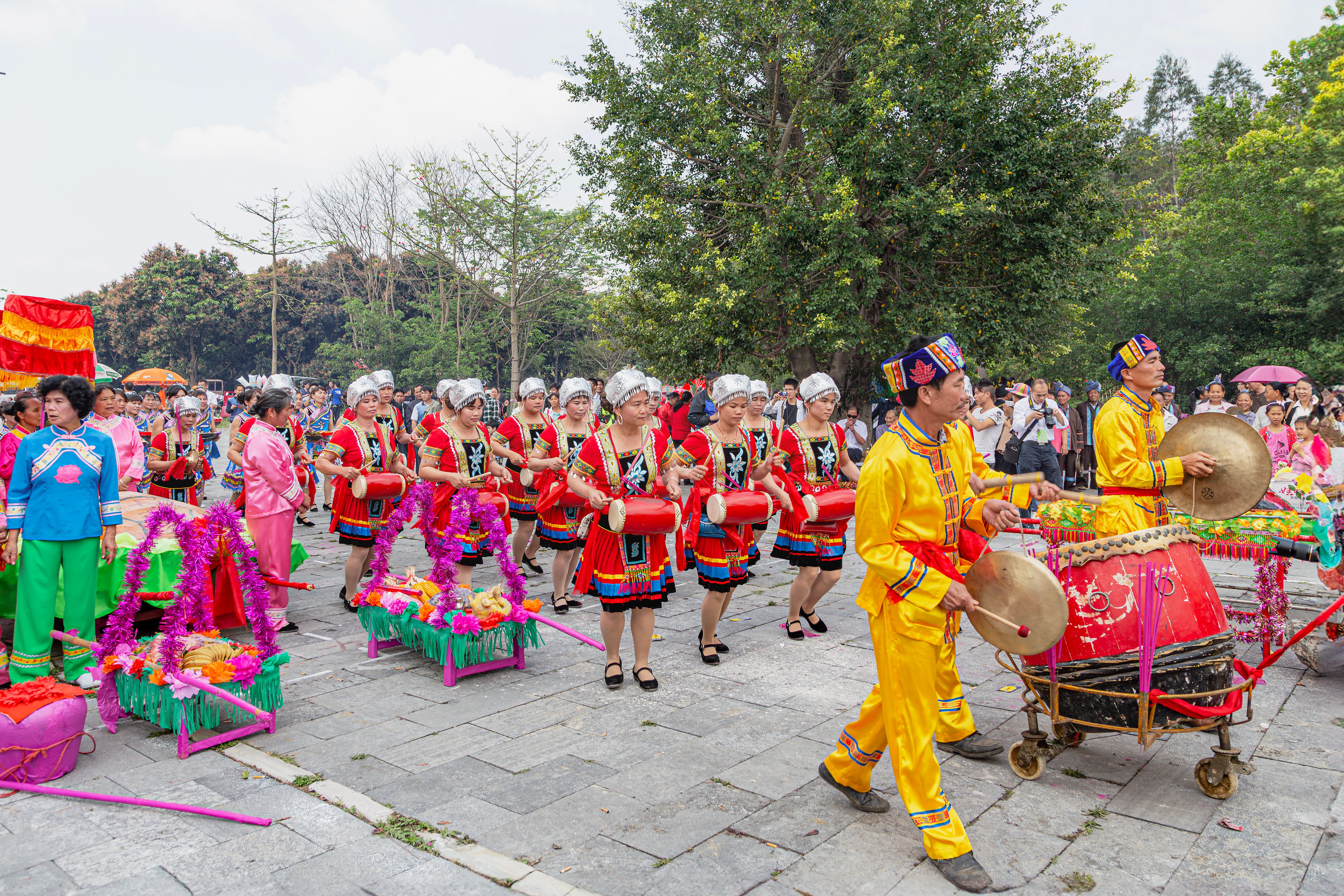 Colorful parade showcasing traditional attire and music in Guangxi, China.