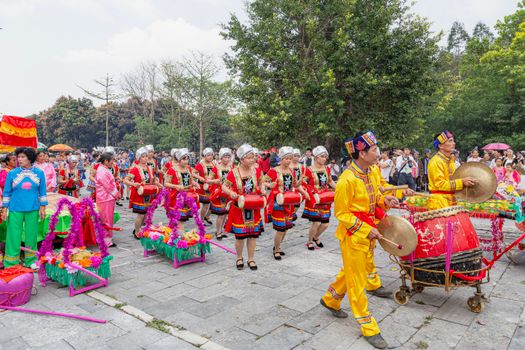 Colorful parade showcasing traditional attire and music in Guangxi, China.