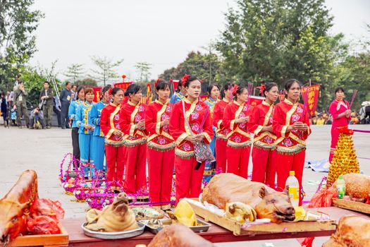 A vibrant traditional ceremony with people in cultural attire and offerings in Guangxi, China.