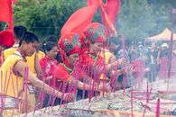 People participating in a vibrant traditional ceremony with incense sticks in Guangxi, China.