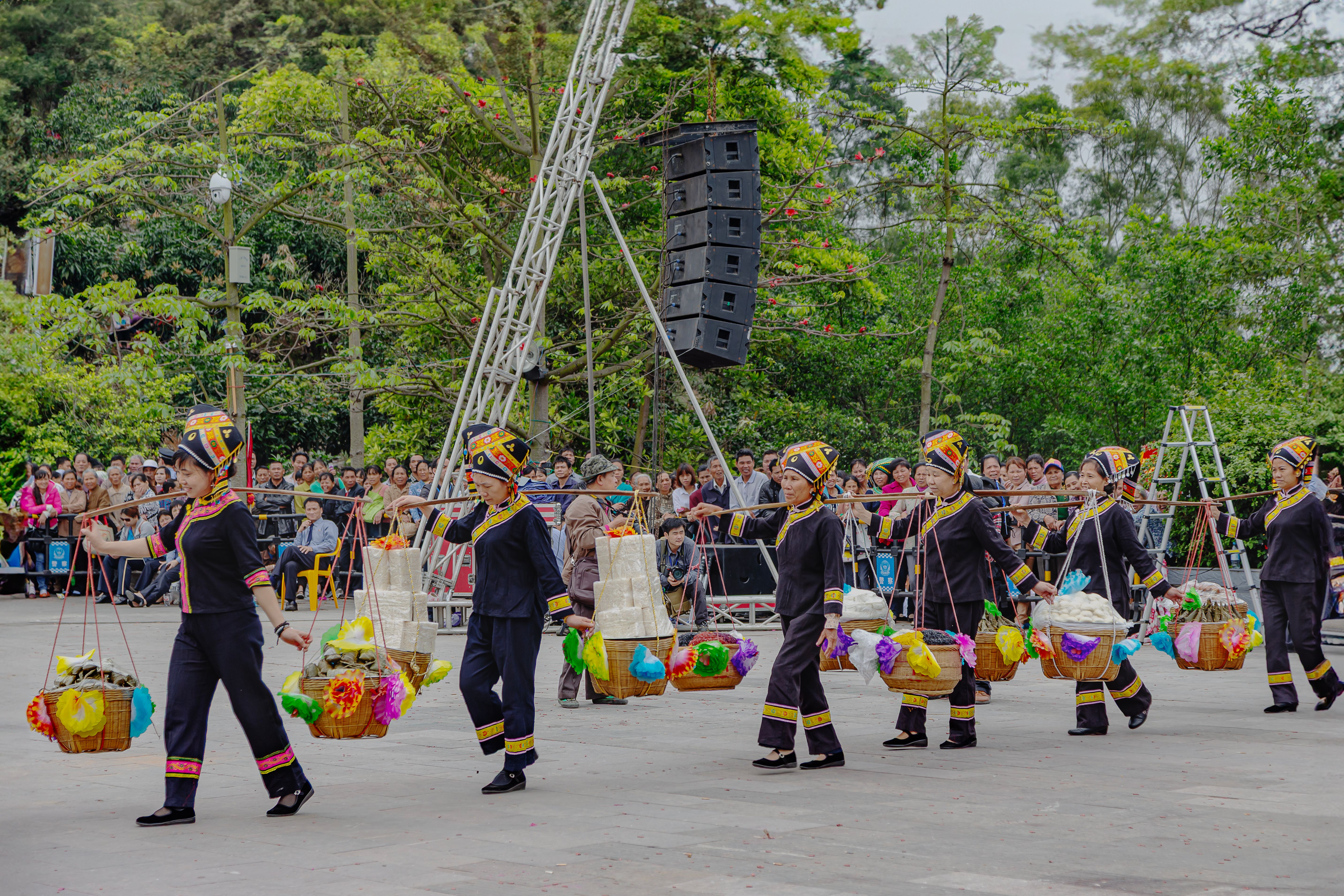 Local women in traditional attire participate in a vibrant festival parade in Guangxi, China.