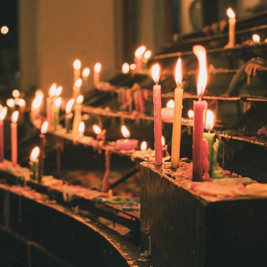 Group of hand-poured candles glowing in a dim room — photo by Clarence Gaspar on Pexels