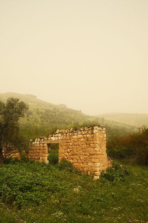 Free A stone ruin in a verdant, foggy landscape evokes history and solitude. Stock Photo