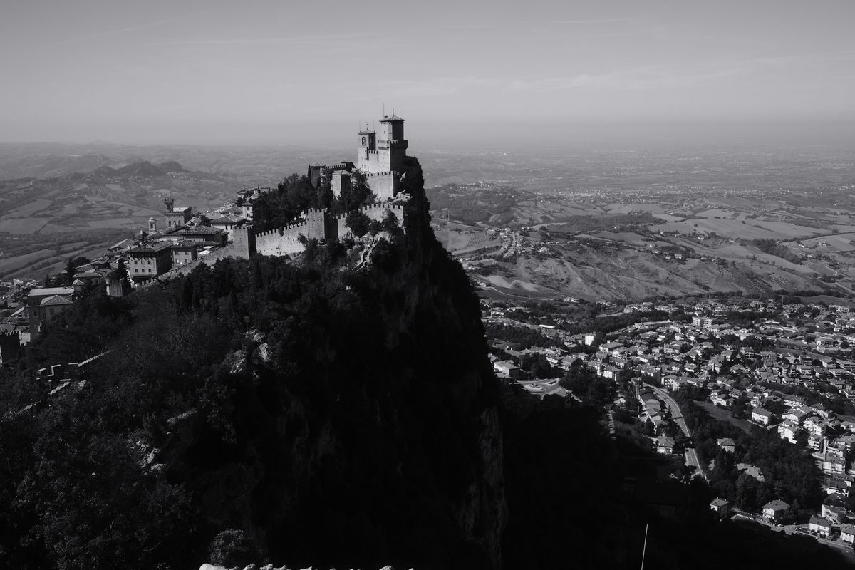Fotografie alb-negru cu fortăreața Guaita și orașul de la poalele Muntelui Titano
