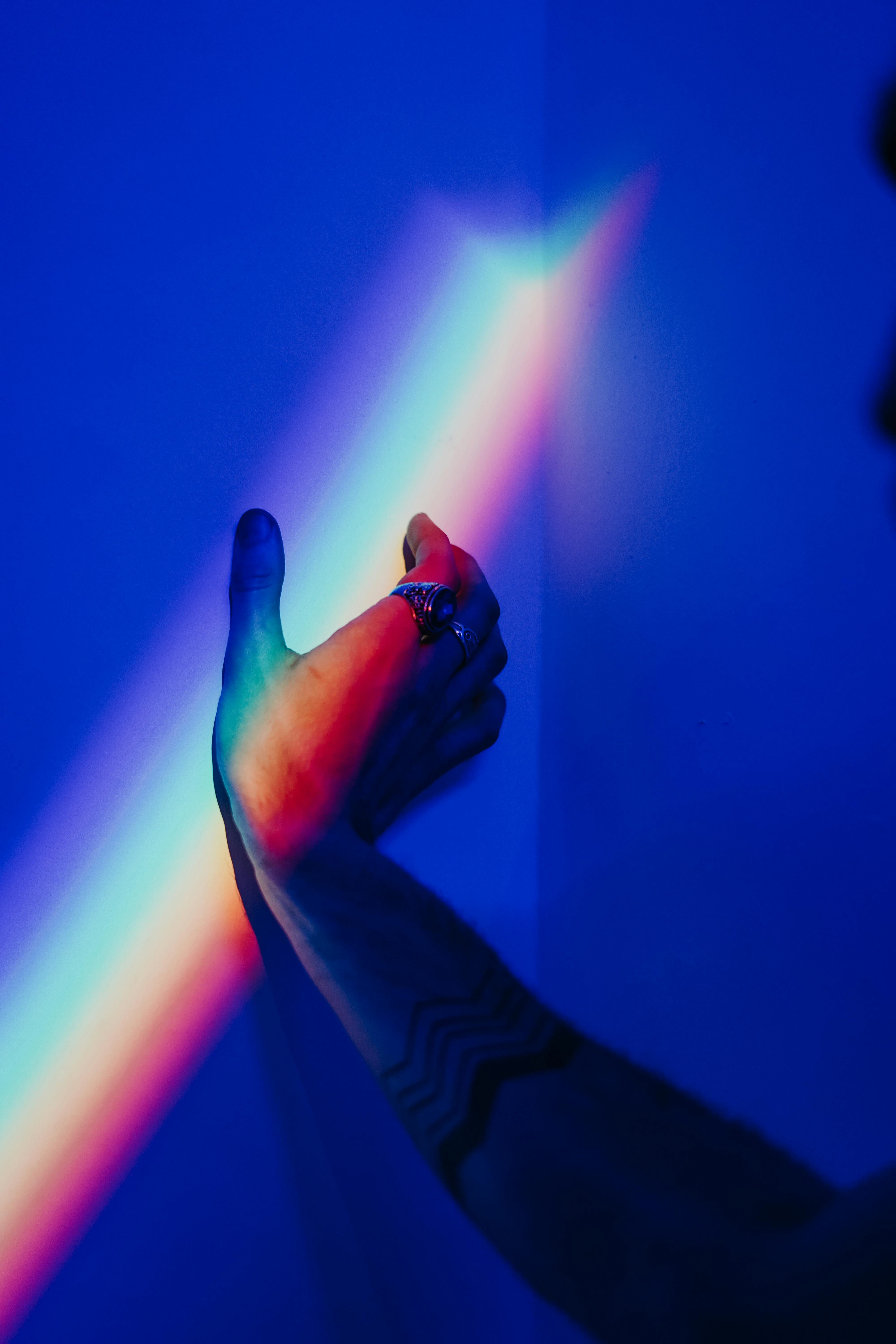 photo of person s hand touching the wall with rainbow colors