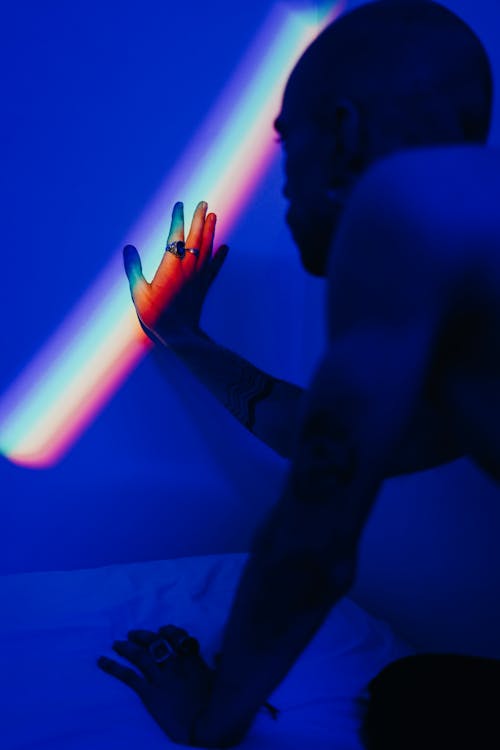 Photo of Man Touching the Wall With Rainbow Colors