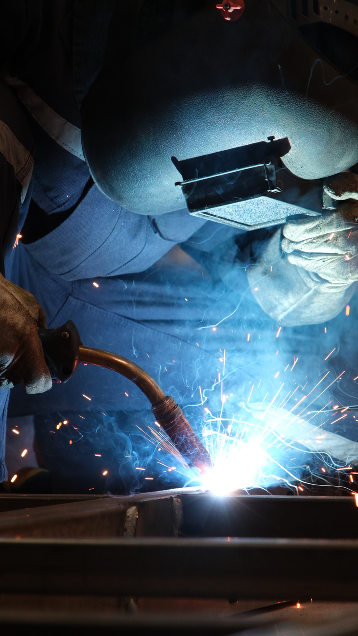 Intense welding process with sparks in an Istanbul industrial workshop, showcasing craftsmanship and safety.
