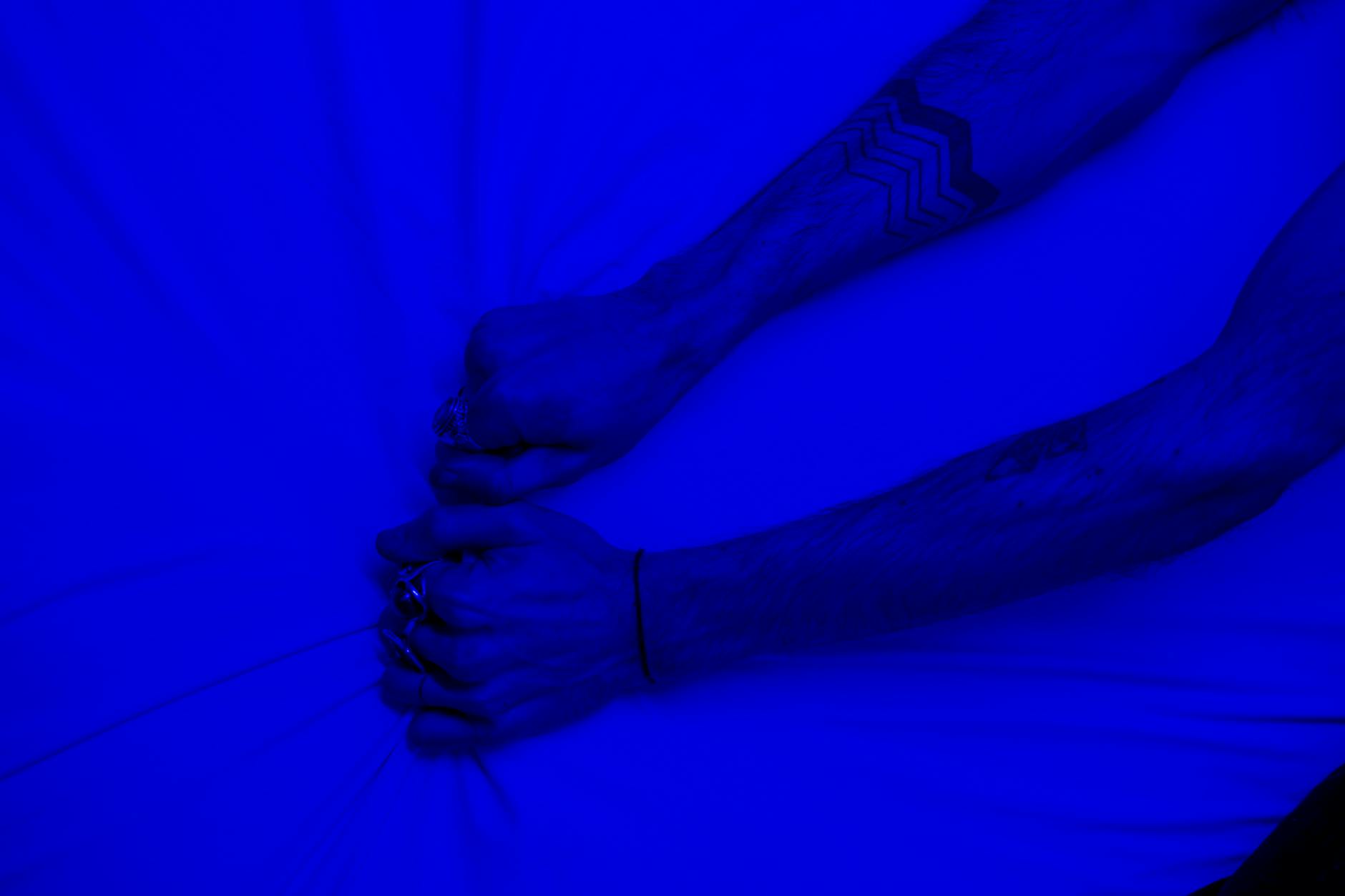 Persons Hand on Blue Textile