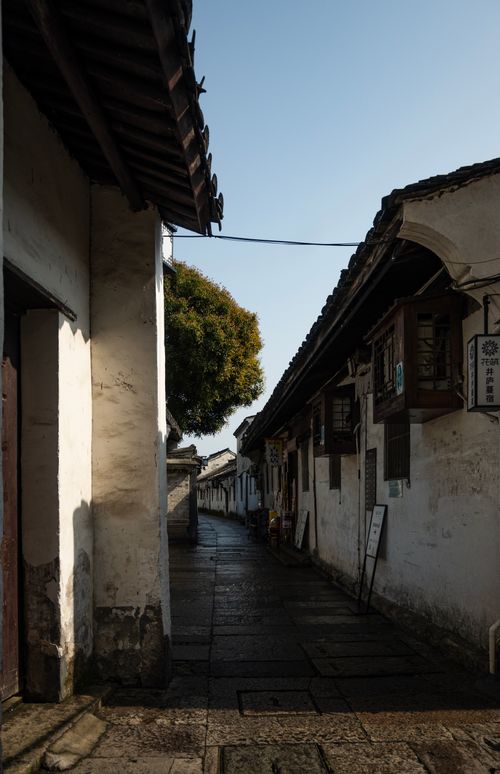 Free Explore a tranquil ancient alleyway with traditional Asian architecture under a bright clear sky. Stock Photo