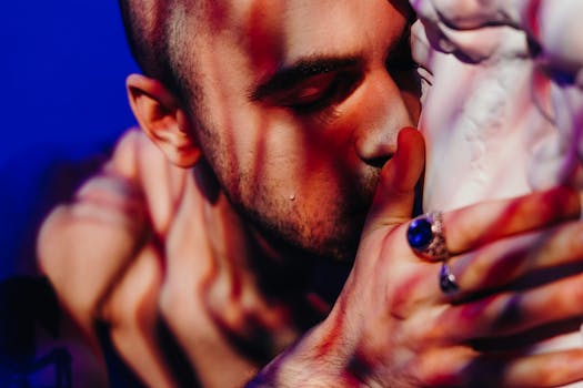 一个男人温柔亲吻雕塑的特写肖像，艺术照明烘托出情感