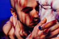 特写一个拿着雕塑的男人，神情悲伤