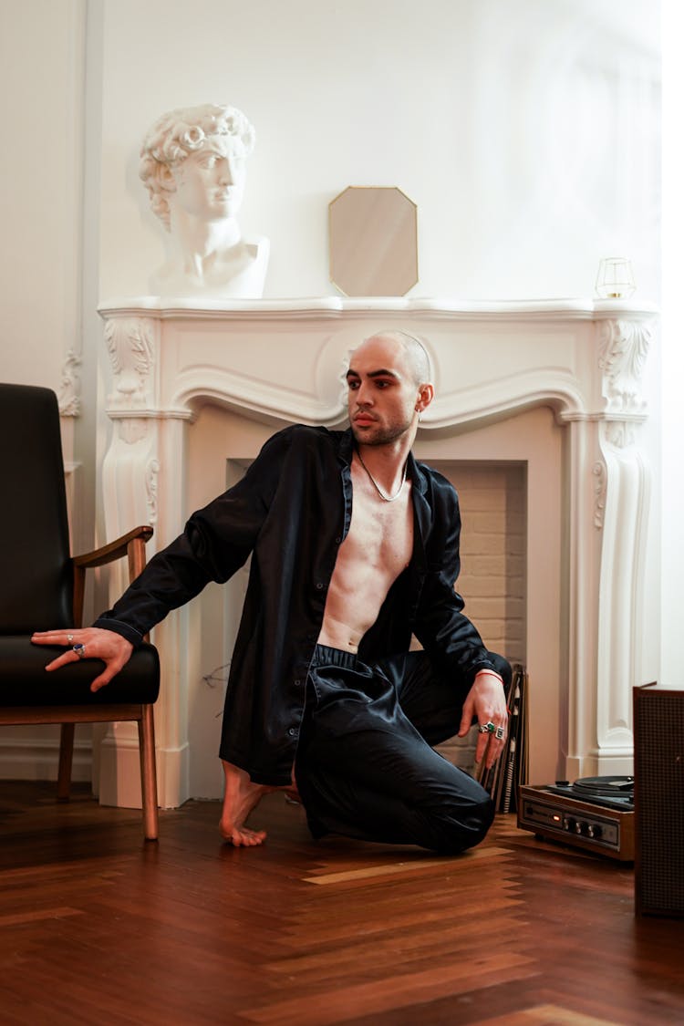 Man In Black Jacket Kneeling Near Fireplace