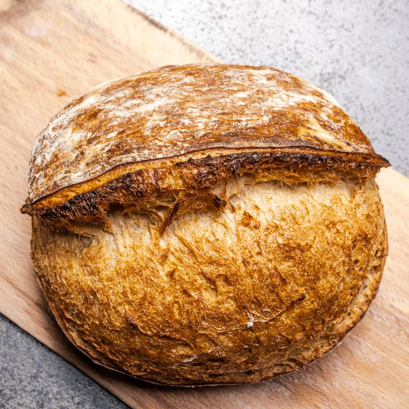 A golden sourdough loaf with a deep score across the top