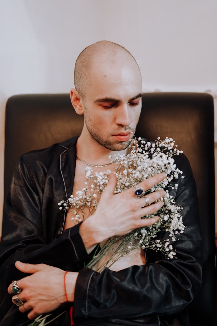 Man In Black Suit Holding A Flowers