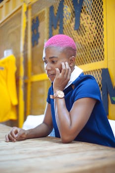 一位粉红色头发的时髦女人坐在室内沉思