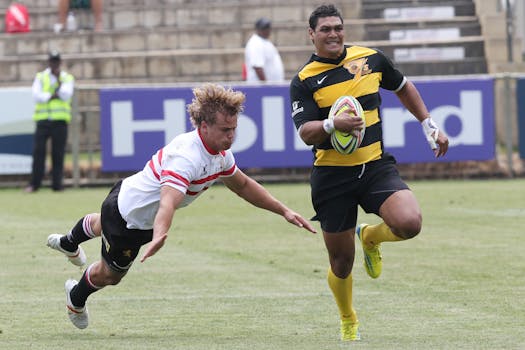 A thrilling moment in a rugby match as one player tackles another on a grass field.