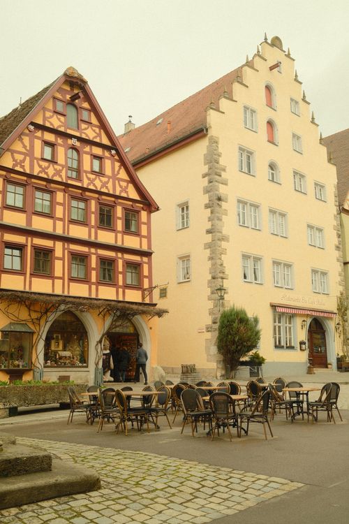 Free A quaint view of medieval buildings and an outdoor cafe in Rothenburg ob der Tauber, Germany. Stock Photo