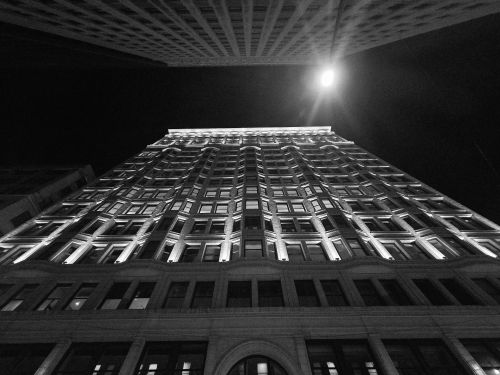 Free Dramatic view of a Chicago skyscraper lit at night, captured in black and white from below. Stock Photo