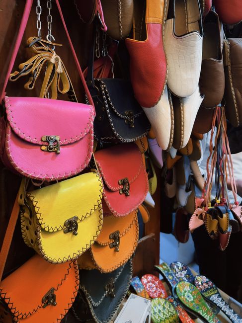 Vibrant leather handbags and traditional shoes on display in a market setting. - Tips for Identifying Quality Handbags When Shopping Online