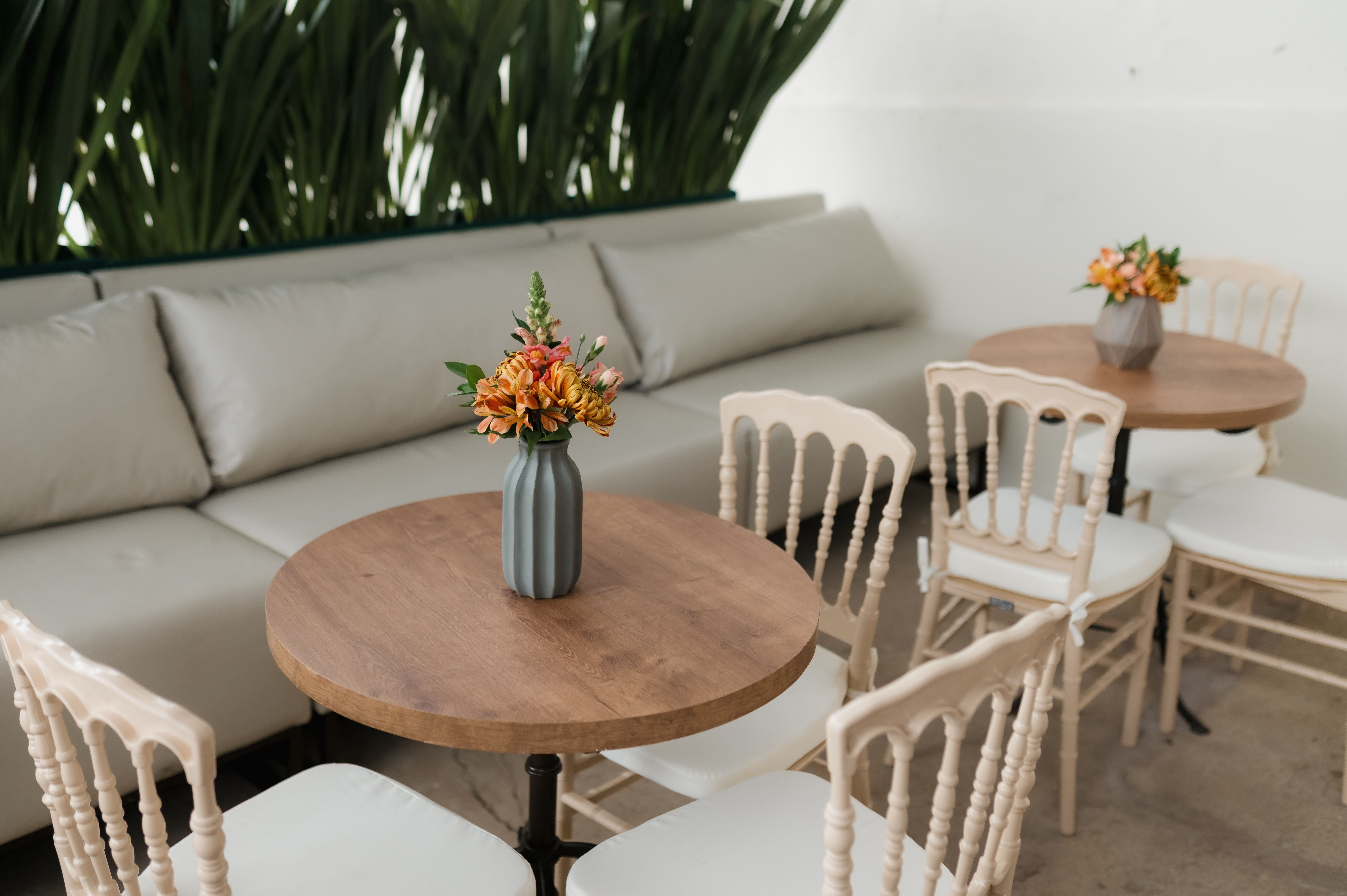 Inviting indoor cafe with round wooden tables and floral centerpieces, perfect for relaxation.