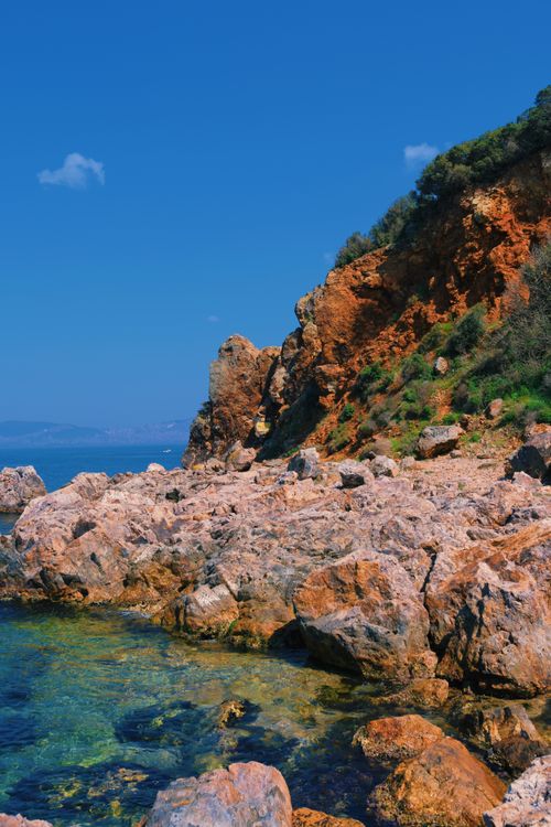 Free Breathtaking view of rocky coastline with crystal clear waters and bright blue skies. Stock Photo