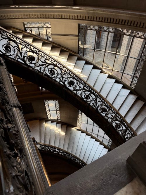 Free Elegant spiral staircase with ornate ironwork in a historic building, showcasing architectural beauty. Stock Photo
